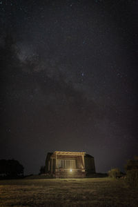 House on land against sky at night