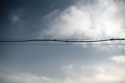 Old power lines silhouette on moody cloudy sky