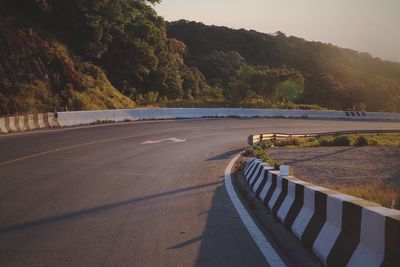 Road by trees against mountains