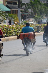 Rear view of people walking on road