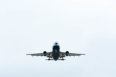 Low angle view of airplane flying against clear sky