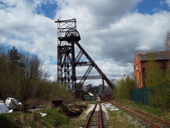 Railroad tracks by trees against sky