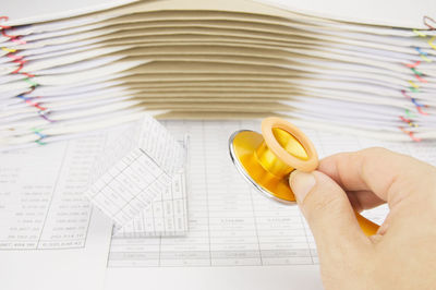 Cropped hand of doctor holding stethoscope over paper