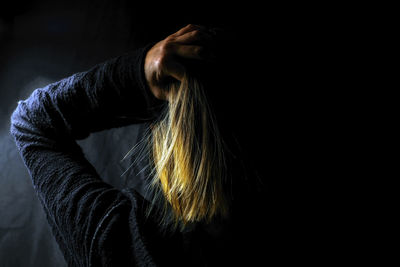 Full length portrait of woman against black background