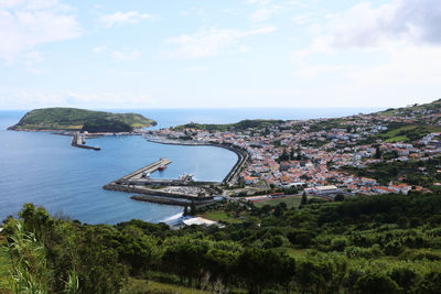 High angle view of townscape by sea against sky