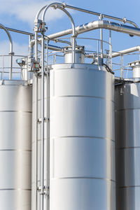 Low angle view of storage tanks against sky