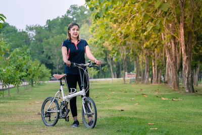 Portrait of man with bicycle on field