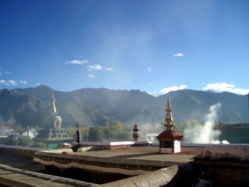 Buddhist monastery by mountains against sky