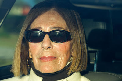 Senior elegant lady enjoying sunset from a car at the coast