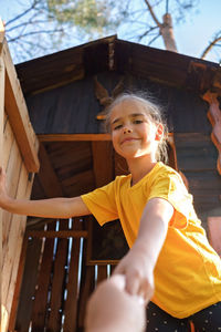 Girl plays in creative handmade treehouse in backyard, summer activity, happy childhood, cottagecore