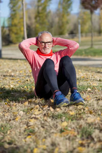 Senior man exercising on field at park