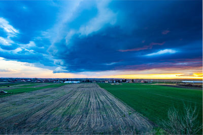 Scenic view of agricultural field against sky during sunset