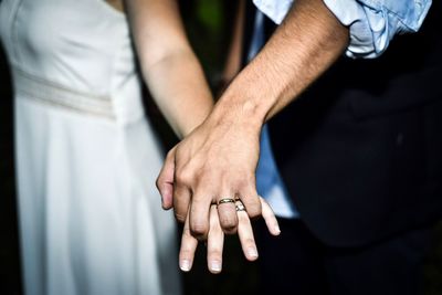 Close-up of couple wearing rings while holding hands