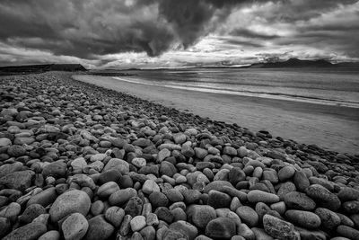 Scenic view of beach against cloudy sky