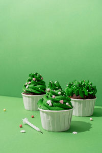 Merry christmas and happy new year. composition of green christmas tree shaped cupcakes