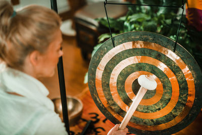 Therapist playing equipment while performing music therapy at spa