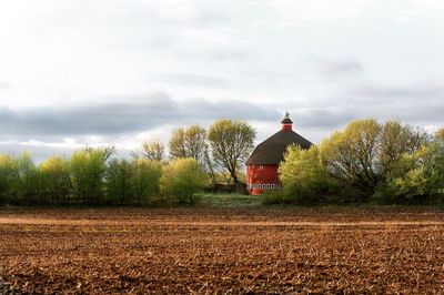 View of landscape with barn against sky