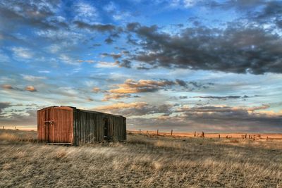 Scenic view of abandoned barn in grassy field