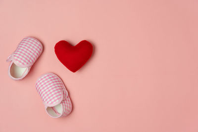 High angle view of heart shape on pink over white background