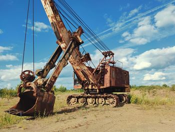 Old mining excavator on a background of blue sky with clouds on a sunny day