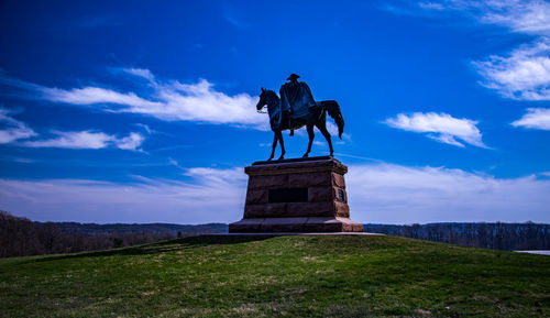 Statue against cloudy sky