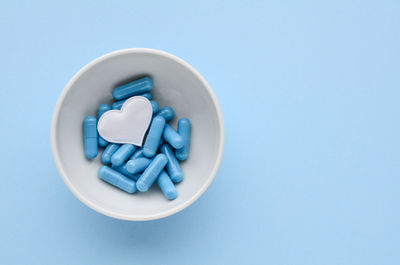 Blue medical capsules in white bowl, white heart  prevention valentine's day. medical.