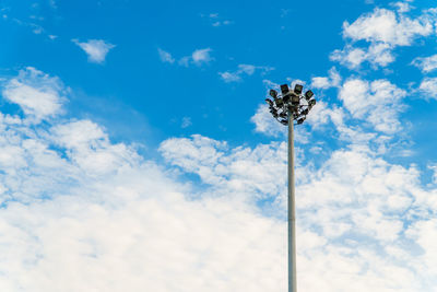 Low angle view of floodlight against blue sky