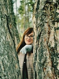 Woman standing on tree trunk