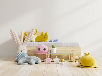 Stuffed toys on floor against wall