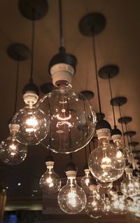 Low angle view of illuminated light bulb hanging at home
