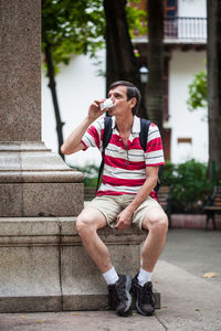 Male tourist drinking colombian coffee at the bolivar square in cartagena de indias