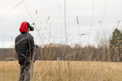 Young man launches rc plane into sky. teenager with glasses playing with toy radio-controlled air