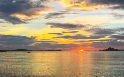 Scenic view of sea against cloudy sky during sunset