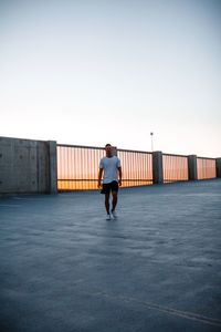 Rear view of man standing against clear sky