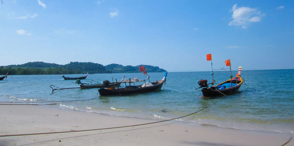 Boats moored on sea against sky