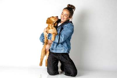 Young woman with dog against white background