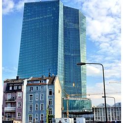 Low angle view of modern building against cloudy sky