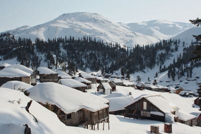 Houses on snow covered landscape against sky