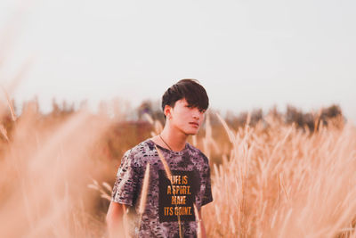 Portrait of man standing by plants against sky