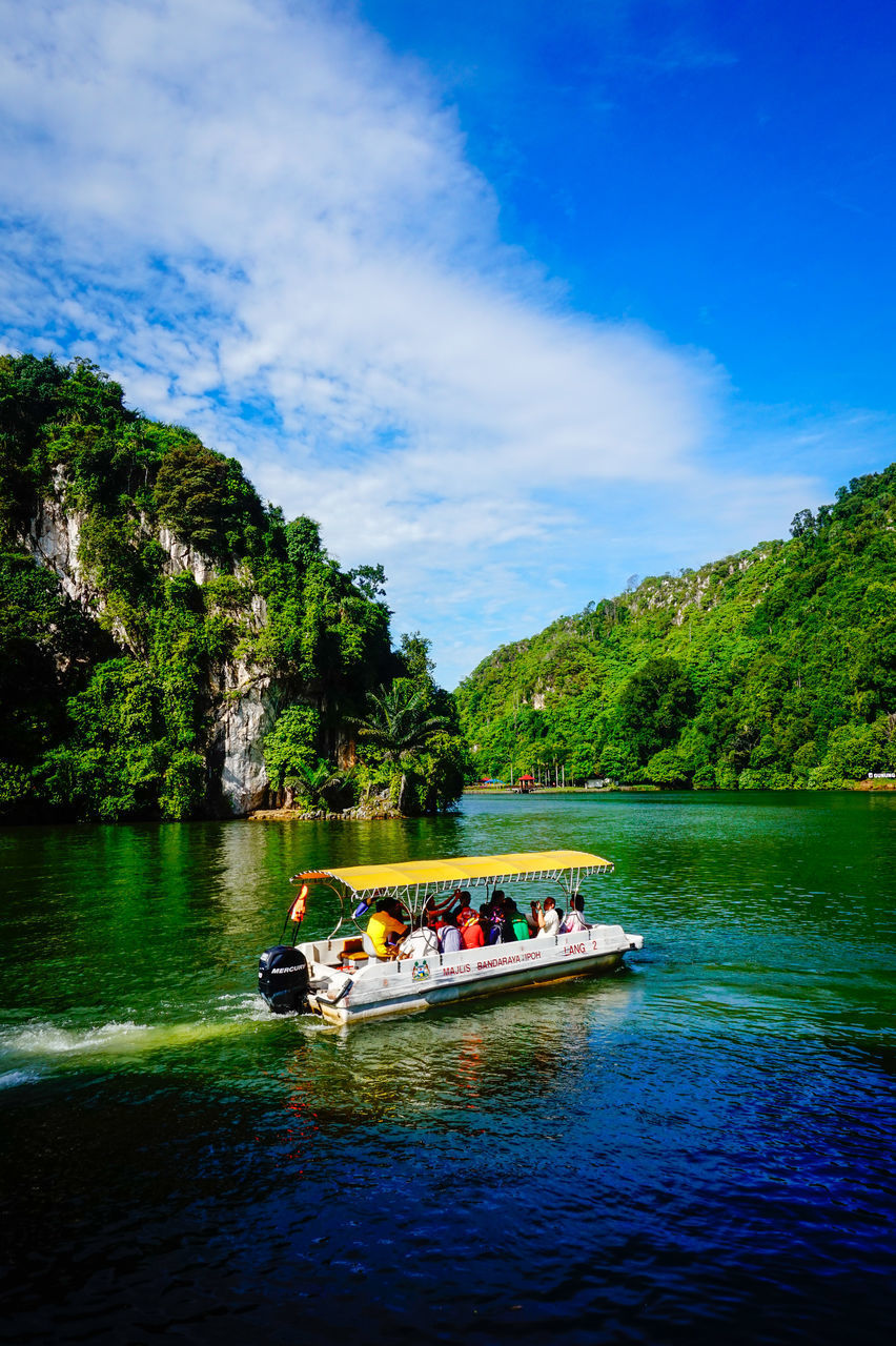 PEOPLE IN BOAT AGAINST RIVER