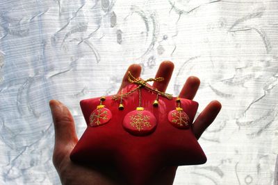 Close-up of hand holding red paper