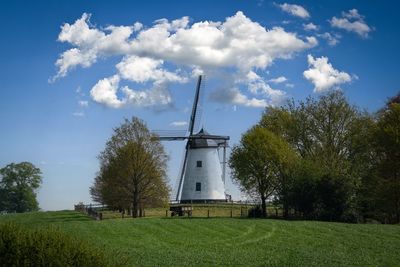 Windmill on field against sky