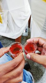 Friends holding alcohol in shot glass