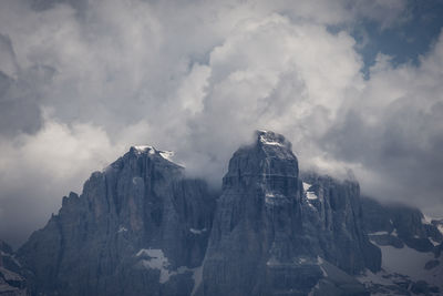 Low angle view of snowcapped dolomites mountains against sky 