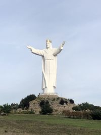 Statue of cross against sky