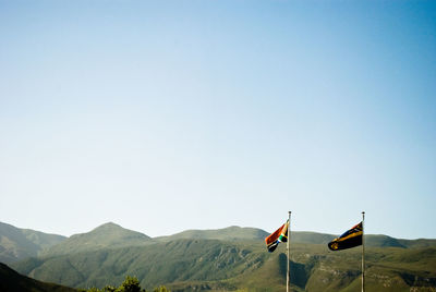 South african flag and mountains against clear sky on sunny day