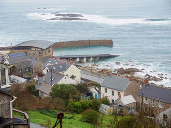 High angle view of townscape by sea against sky
