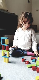 Cute girl playing with toy sitting at playground