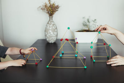 Mother and son making geometric shapes from sticks and play dough.