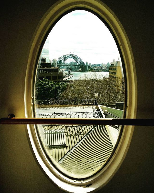 architecture, indoors, built structure, window, glass - material, circle, transparent, building exterior, geometric shape, reflection, city, sky, modern, arch, tree, no people, metal, clear sky, day, building